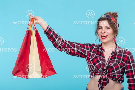 Positive young beautiful woman in a plaid shirt and...