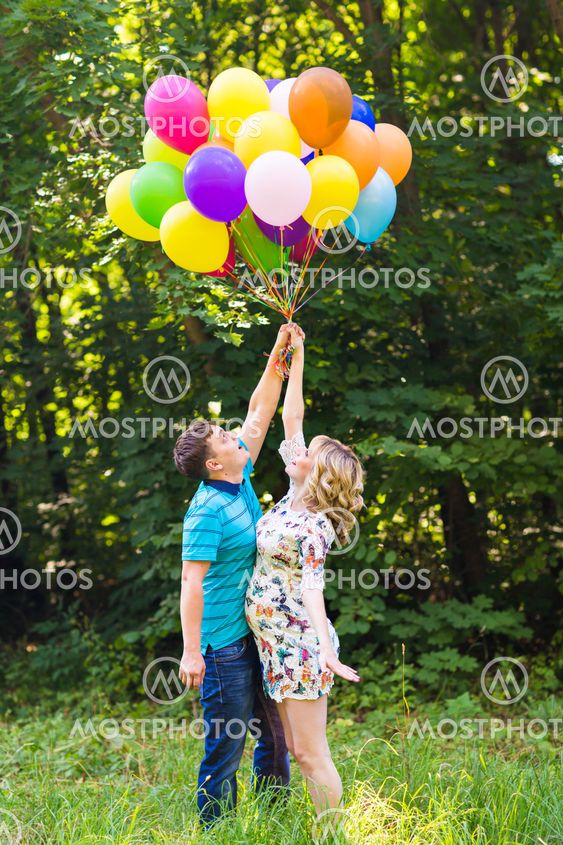 young couple man and his pregnant wife with balloons...