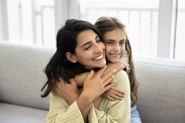 Close up little girl cuddling tightly her young...