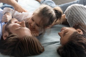 Happy parents have fun with small daughter at home