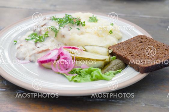 Mashed potatoes with creamy mushroom sauce and pickled cucumber