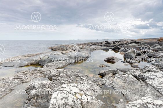 Dramatic, threatening rocky coastline, dark clouds and sea