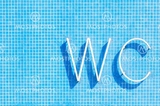 WC sign for toilet on blue wall