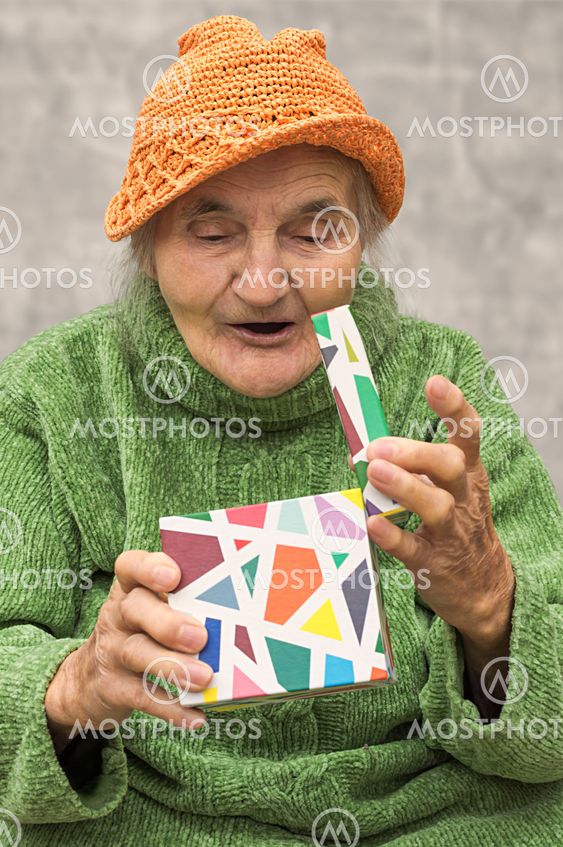 Happy and surprised elderly woman after opening gift box.
