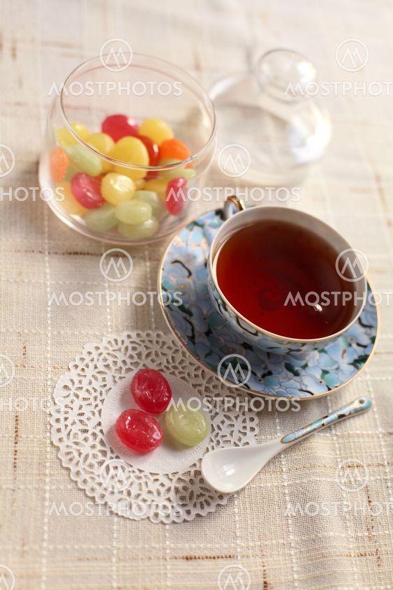 Tea with coloured sugar candies in a glass can