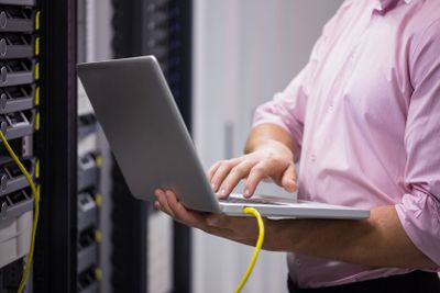Mid section of a technician typing on his notebook