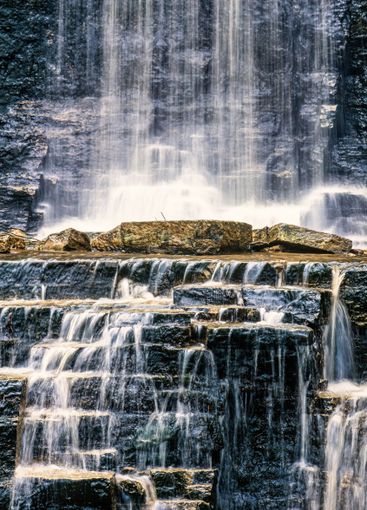 Flowing water on the rocks by a waterfall