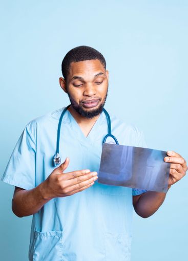 Medical assistant examining x ray scans and providing...