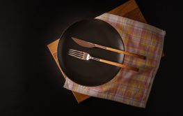 Fork and knife on a plate, isolated on a black...