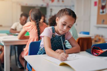 Writing, student and learning with girl in classroom for...