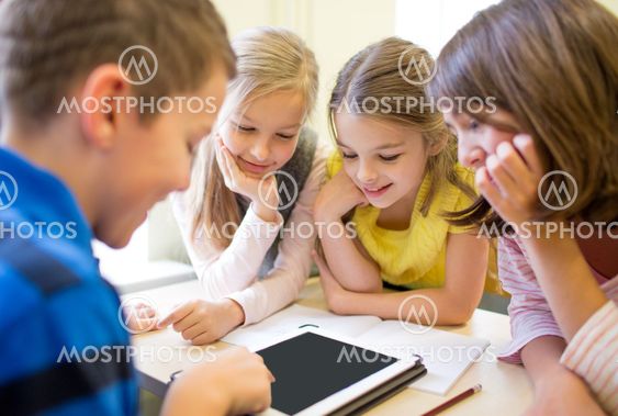 group of school kids with tablet pc in classroom