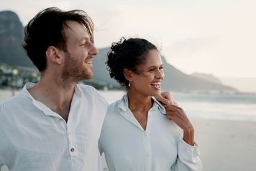 Holiday, travel and interracial couple embrace at beach...