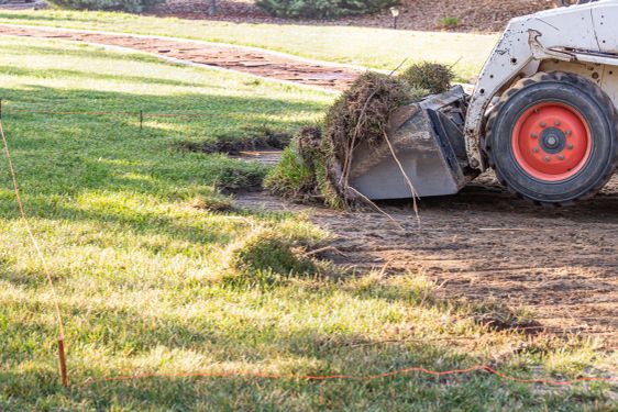 Small Bulldozer Removing Grass From Yard Preparing For...
