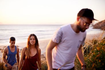 Friends, travel and walk at ocean for adventure, summer...