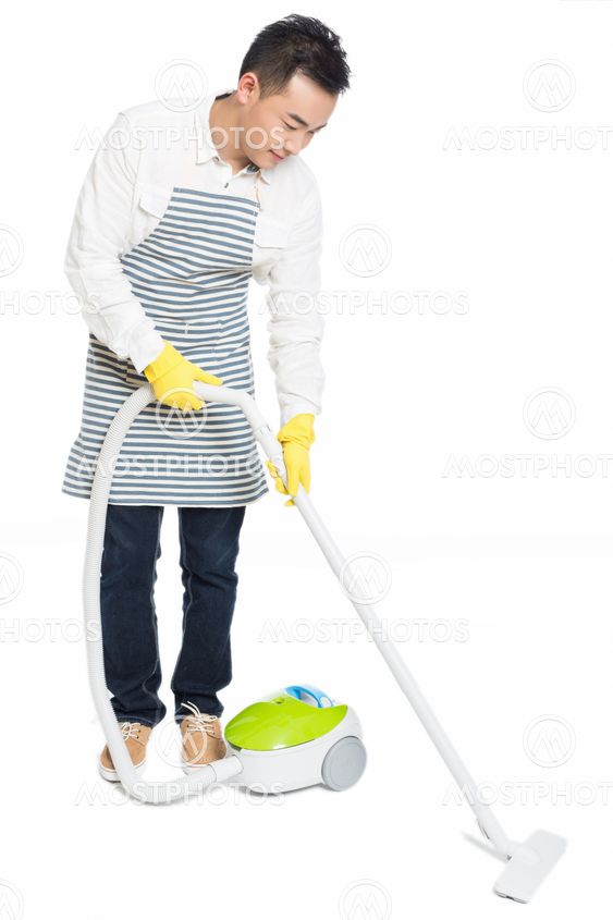 young man uses vacuum cleaner