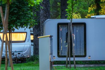 Campers Parked in Lush Greenery During Dusk With...