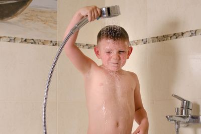 Boy holding shower over his head