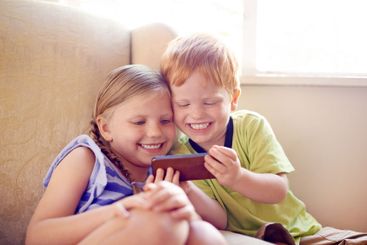 Fun, siblings and children with smartphone, bonding and...