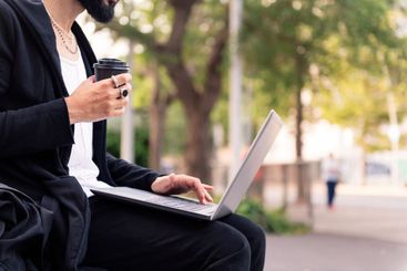 man working with a laptop outdoors in the city