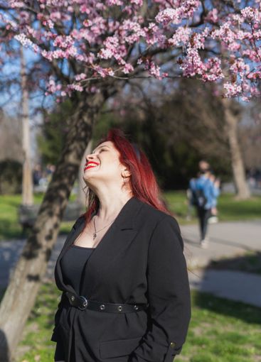 Woman with cherry flowers surrounded by blossoming trees...