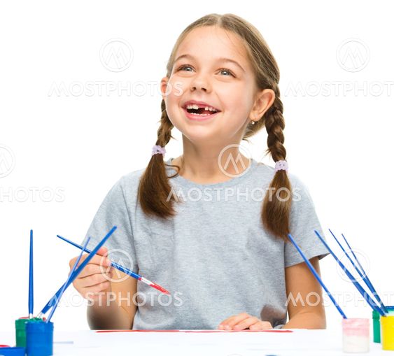 Little girl is painting with gouache