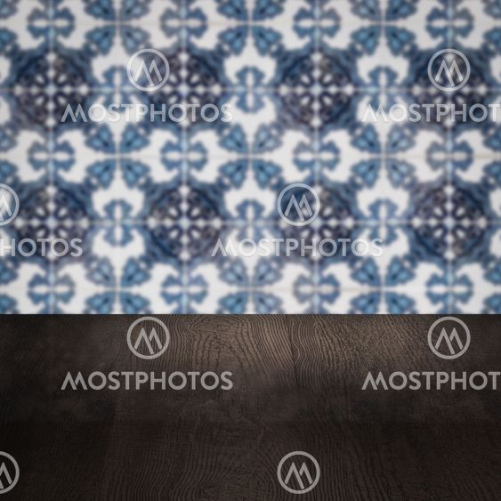 Wood table top and blur vintage ceramic tile pattern wall