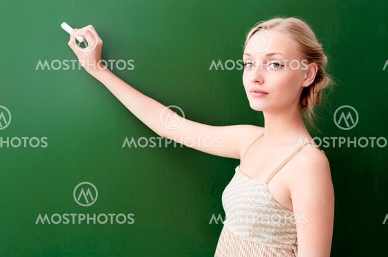teacher writes on the blackboard with chalk