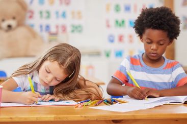 Students, children and coloring in book in classroom for...