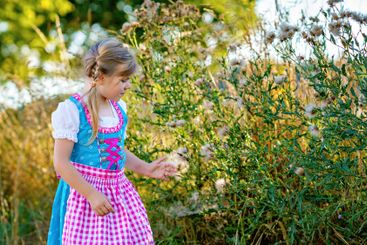 Cute little kid girl in traditional Bavarian costume in...