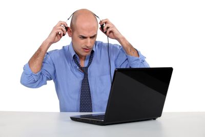 Bald businessman with laptop and headphones