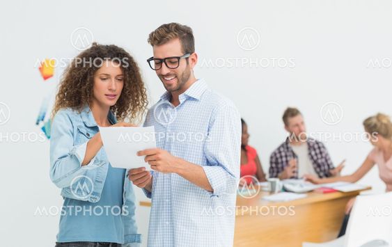 Attractive designers looking at digital tablet together