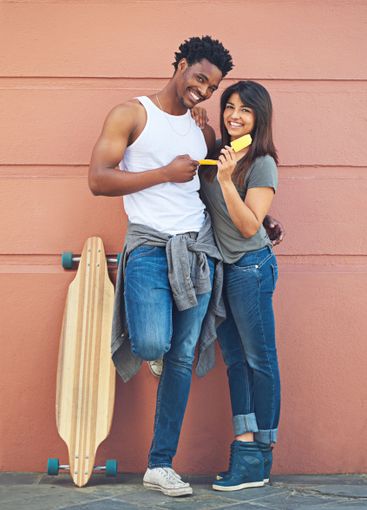 Portrait, fashion and couple with skateboard, wall and...