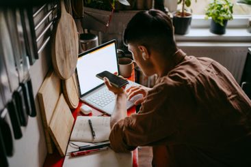 High angle view of male freelancer talking on smart phone...