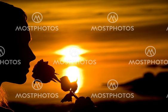 woman in sunset with a rose