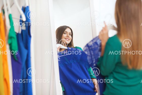 happy woman choosing clothes at home wardrobe
