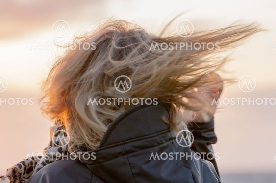 Blond kvinna med vind i håret i solnedgång - Silvertid