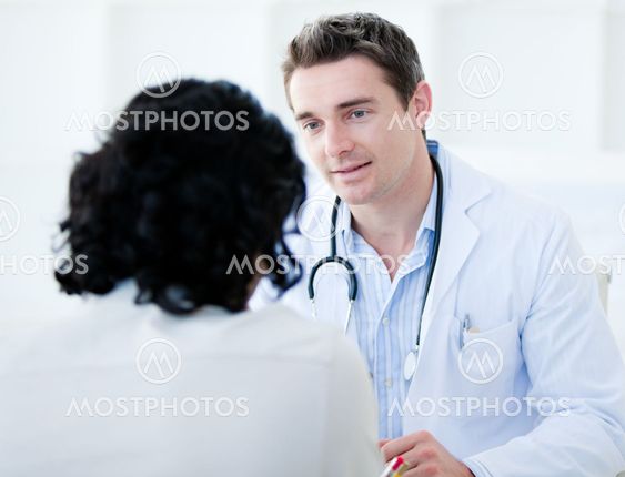 Handsome doctor talking with his patient for the annual check-up