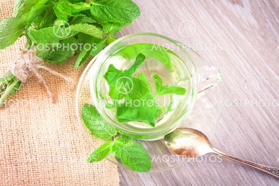 Cup of mint tea on the kitchen table, top view