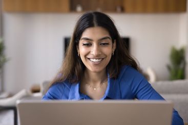Young Indian student woman studying on-line using laptop