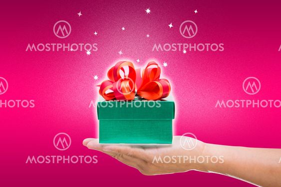 Green gift box with hand on pink background