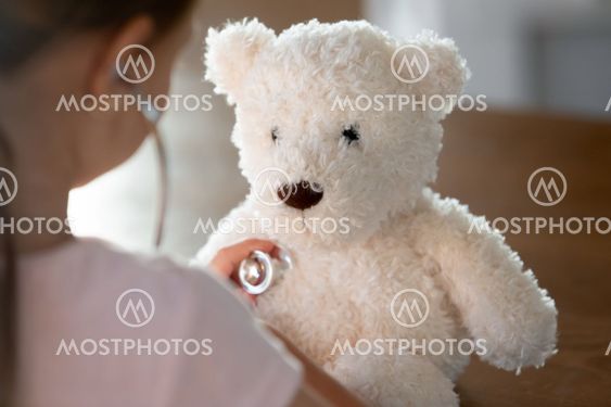 Caring little kid examine plush teddy bear