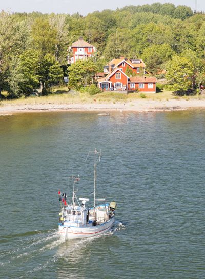 Small fishing boat on the blue sea heading back after...