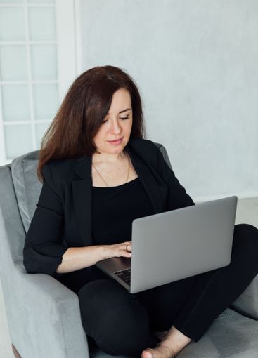 woman brunette sitting on chair online laptop