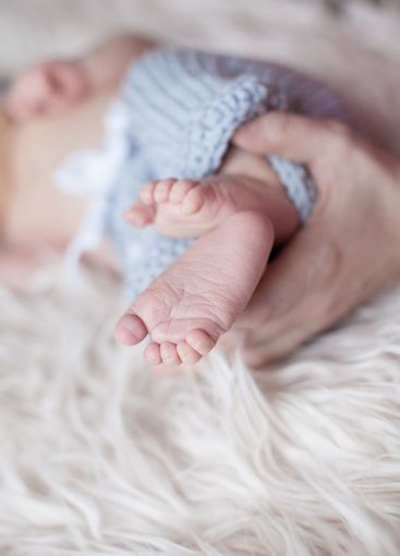 Parent holding in the hands feet of newborn baby on...