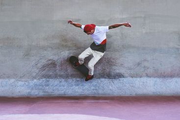 Jump, skateboard and wall with man at park for urban,...