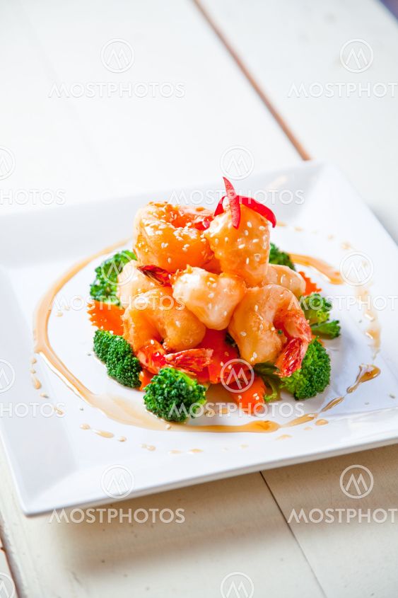 Battered king prawns on a bed of steamed broccoli and carrot top with sweet honey sauce and sasemi seeds.