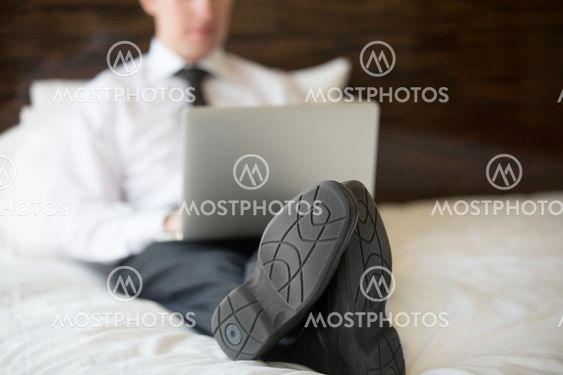 Businessman using laptop in hotel. Close-up