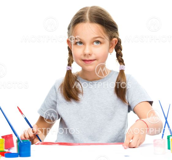 Little girl is painting with gouache