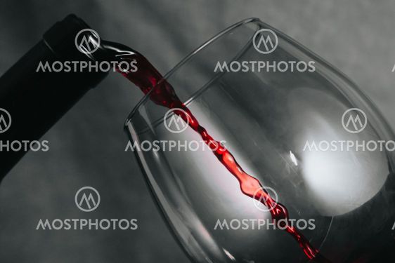 A bottle of wine serving wine in a cup with copy space...