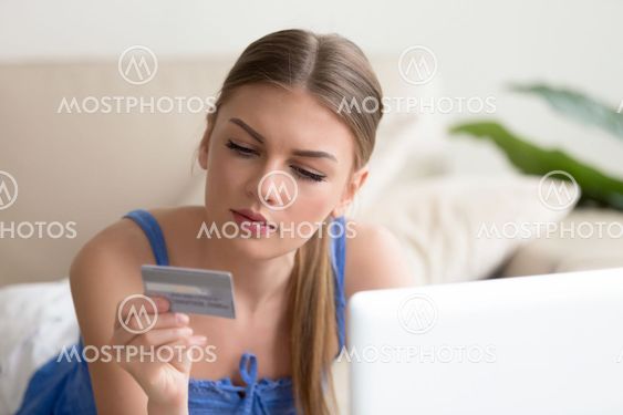 Young woman paying by credit card shopping online at home
